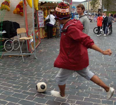 Jorge won a stuffed horse and a ball at a street carnival kicking soccer balls.